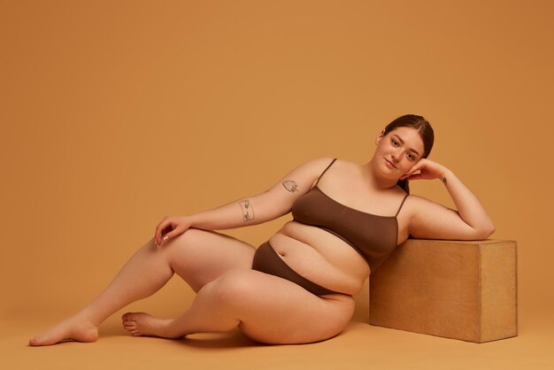 Confident young plus-size woman posing in cotton underwear promoting equal beauty standards.